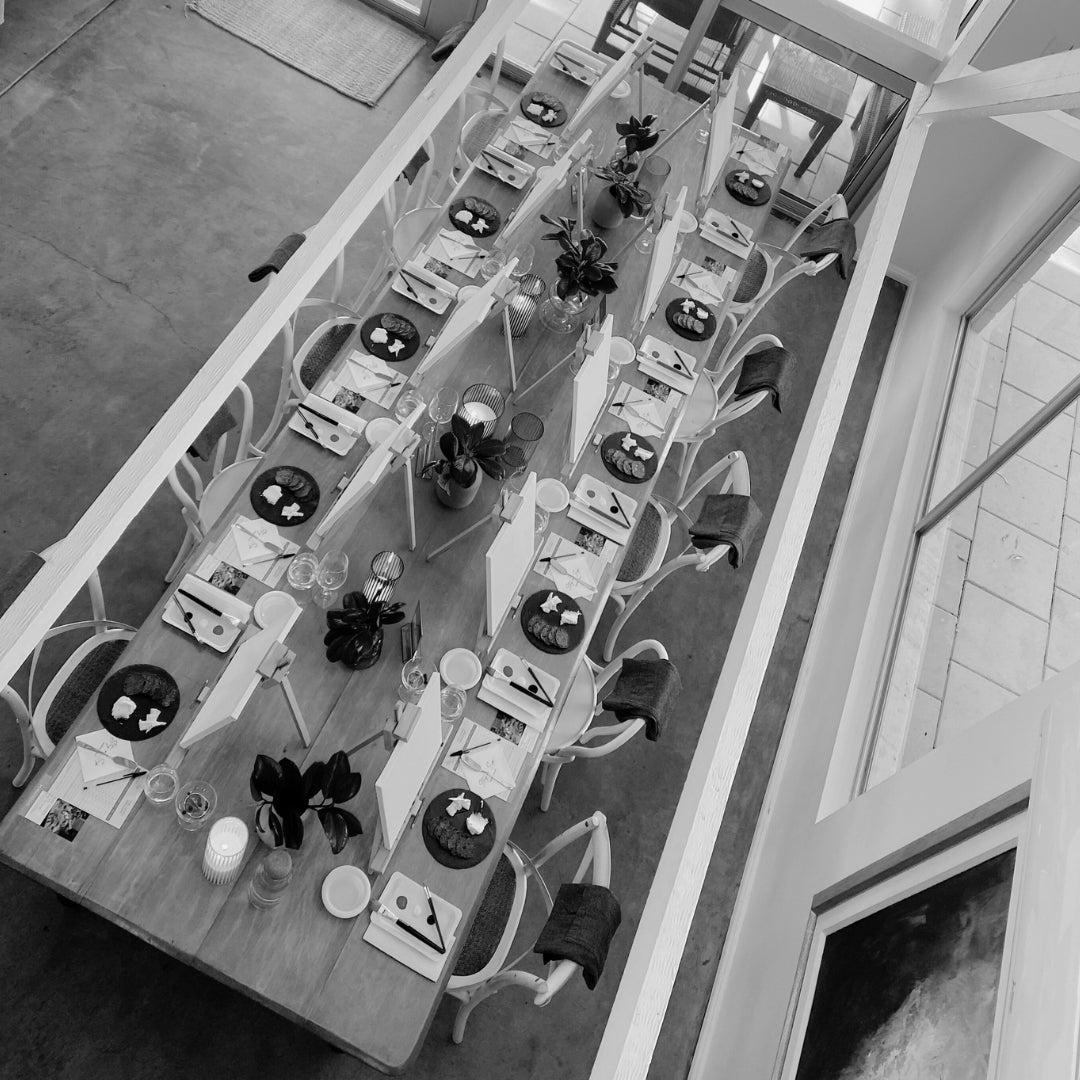 Overhead view of a beautifully arranged Paint n’ Wine Tasting setup by Stay n’ Sip, featuring easels, painting supplies, and wine glasses, creating a creative and inviting atmosphere