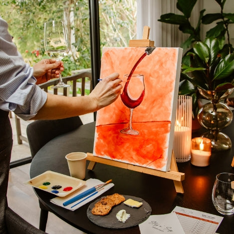 Person painting a wine glass with splash.