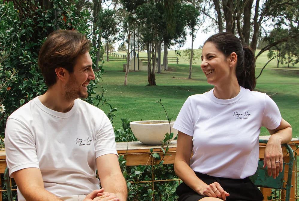 Stay n' Sip hosts laughing while sitting in Australia natural bushland.